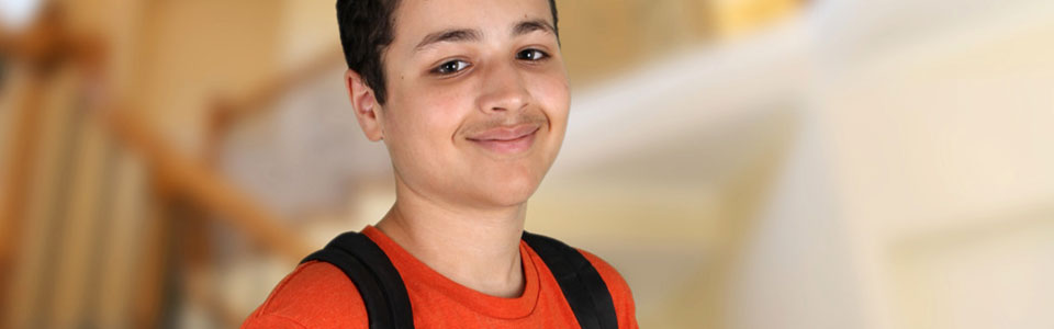 young student smiling and wearing backpack